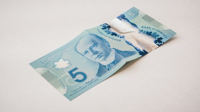 Budget to Reconciliation | Manage Your Property Folded Canadian five-dollar banknote on a pale surface.