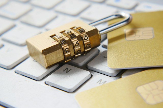 Commercial Security Deposits | Manage Your Property Padlock resting on white computer keyboard with a gold credit card nearby, symbolizing online payment security or data protection.